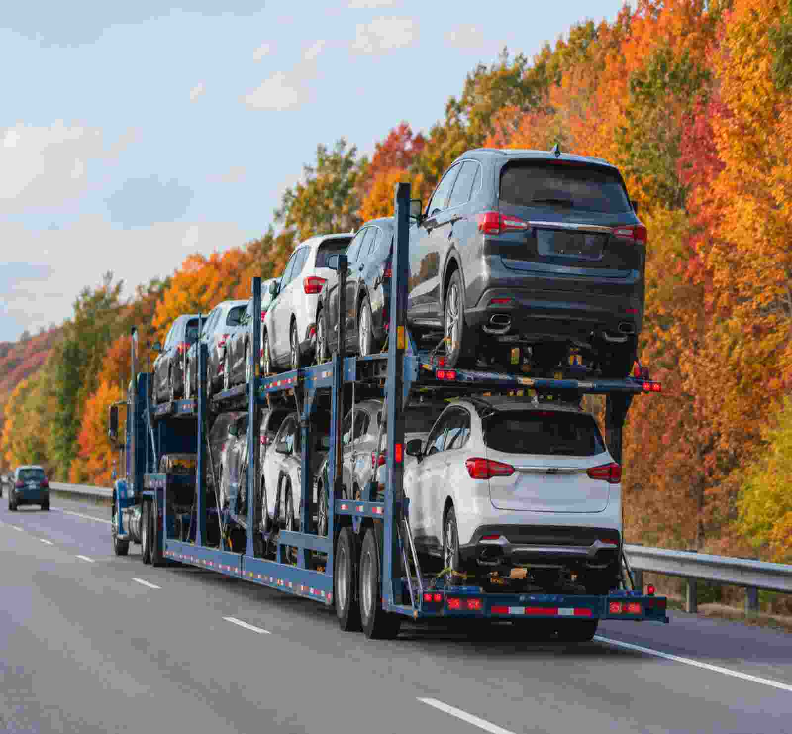 open car carrier taking the cars during fall season in november